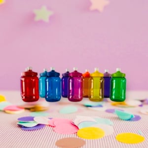 May include: A row of ten colorful plastic water bottles with screw-on lids. The bottles are arranged in a rainbow pattern, with red, blue, purple, pink, yellow, green, and orange bottles.