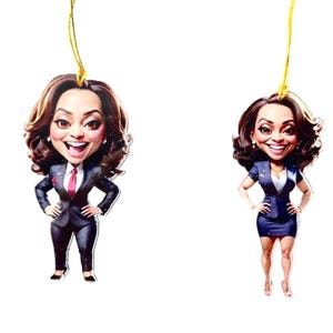 May include: Two cartoon ornaments of a woman in a business suit. One ornament is wearing a blue suit and the other is wearing a black suit. Both ornaments have a gold string for hanging.