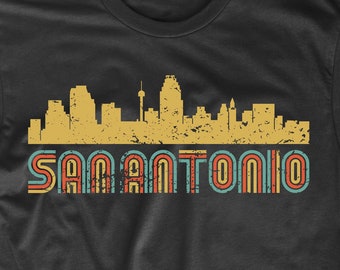 May include: Black t-shirt with a vintage-style skyline of San Antonio, Texas. The skyline is in yellow, and the text "San Antonio" is in red, blue, and yellow.