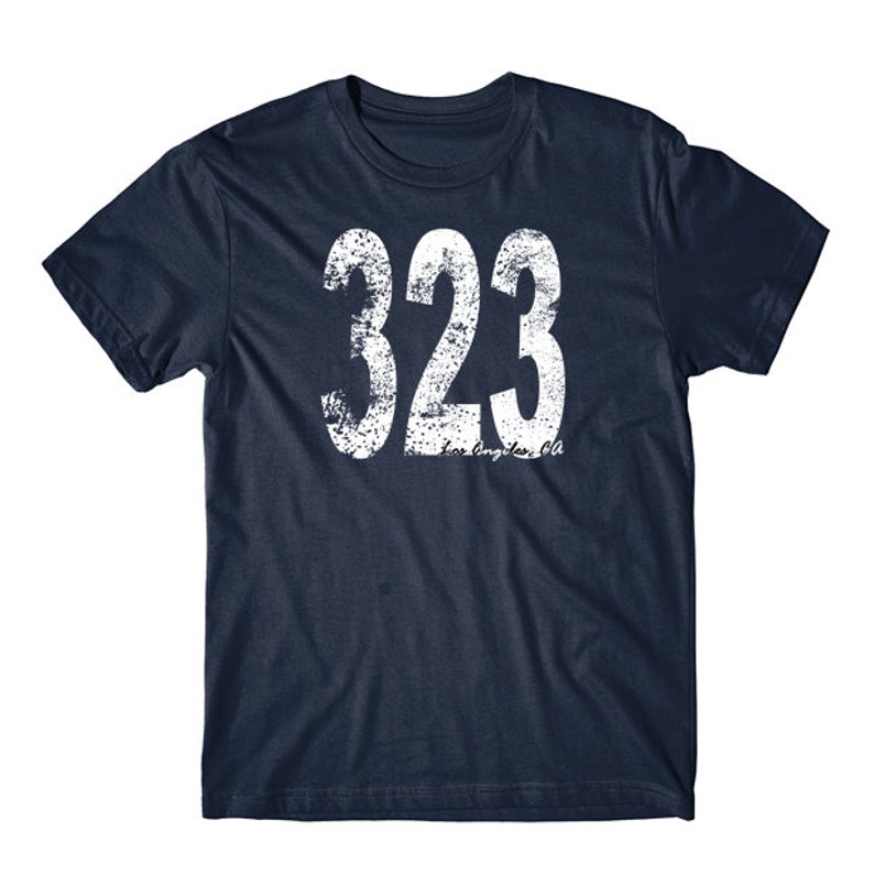 K&ouml;nnte beinhalten: Ein marineblaues T-Shirt mit einer wei&szlig;en, abgenutzten Grafik der Nummer 323 und dem Text "Los Angeles, CA".