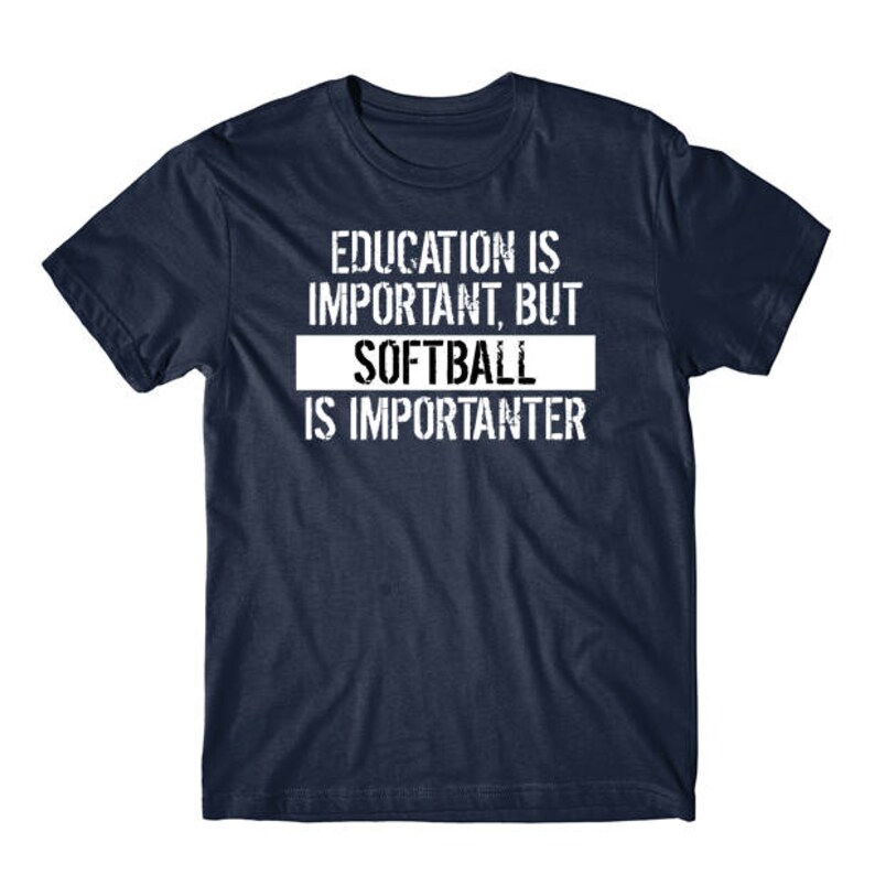 May include: A navy blue short-sleeved t-shirt featuring white distressed-style text that reads: EDUCATION IS IMPORTANT, BUT SOFTBALL IS IMPORTANTER. The word SOFTBALL is highlighted within a solid white rectangular block on the chest.
