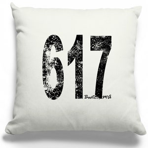 May include: White throw pillow with a black distressed graphic of the number 617 and the text "Boston, MA".