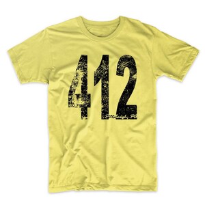 May include: A yellow t-shirt with a black distressed graphic of the number 412 and the text "Pittsburgh, PA".