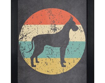May include: A framed wall art print featuring a dark gray silhouette of a Great Dane dog standing in profile. The dog is centered over a circular background composed of horizontal stripes in orange, cream, teal, and yellow with a distressed texture.