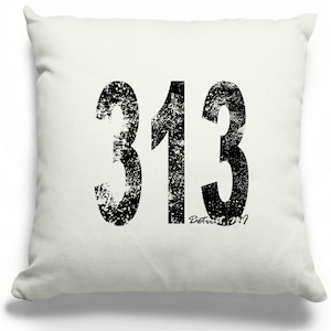 May include: White throw pillow with a black distressed graphic of the number 313. The text "Detroit, MI" is printed in smaller font below the number.