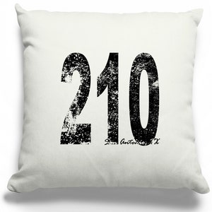 May include: White throw pillow with a black distressed graphic of the number 210 and the text "San Antonio, TX".