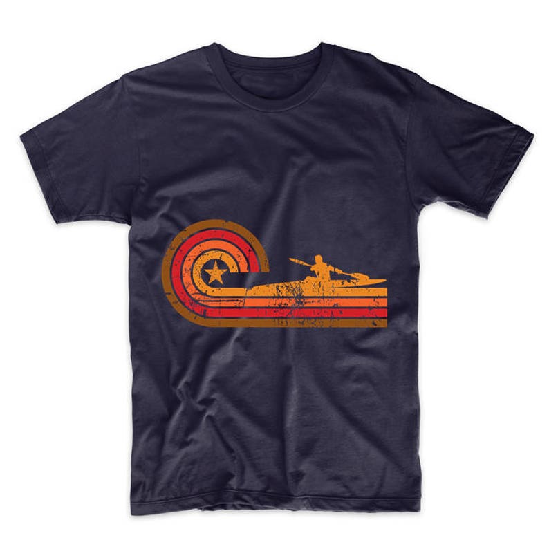 May include: A navy blue t-shirt with a retro-style graphic of a person kayaking in a sunset. The graphic features a red, orange, and yellow color scheme with a white star.