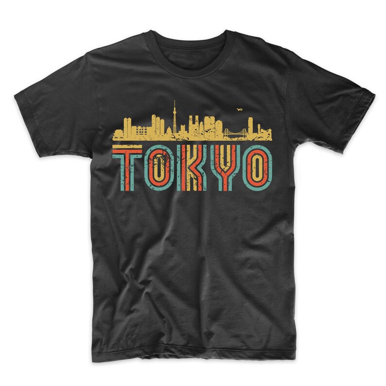 May include: Black t-shirt with a vintage-style graphic of the Tokyo skyline and the word "TOKYO" in colorful, striped letters.