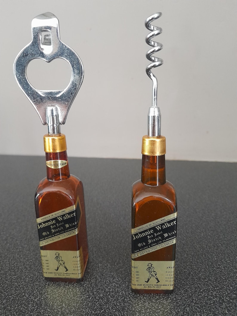 May include: Two miniature Johnnie Walker Old Scotch Whisky bottles with bottle opener and corkscrew tops. The bottles are brown glass with gold labels and black text.