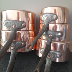 Vintage French heavy copper pan set with fat copper rivets.