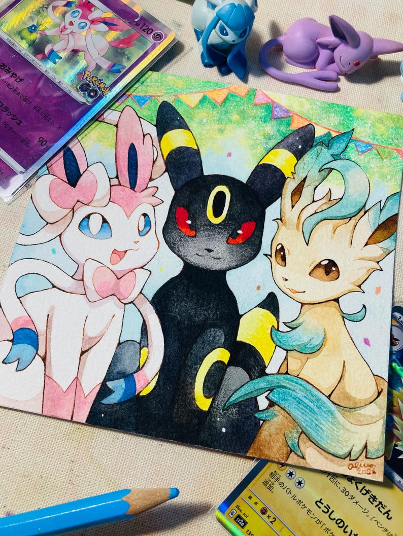 K&ouml;nnte beinhalten: Aquarellillustration von drei Pok&eacute;mon-Charakteren: Sylveon, Umbreon und Leafeon. Sylveon ist rosa und wei&szlig;, Umbreon ist schwarz mit gelben Akzenten und Leafeon ist hellbraun und gr&uuml;n. Pok&eacute;mon-Sammelkarten und Figuren umgeben das Kunstwerk.