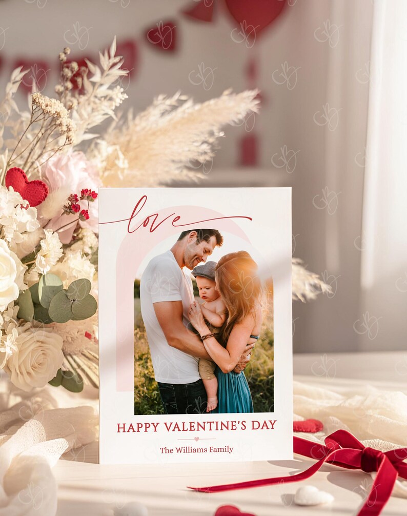 May include: A Valentine's Day card featuring a family portrait with a soft, warm color palette. The word "love" is written in cursive above the photo, and "Happy Valentine's Day" is printed below. The family is embracing, with a soft pink rainbow arching behind them.