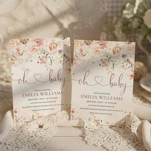 K&ouml;nnte beinhalten: Zwei Babyparty-Einladungen mit floralen Designs. Die Einladungen zeigen die Worte "oh baby" in Schreibschrift, zusammen mit Veranstaltungsdetails. Die Einladungen sind mit einem floralen Muster in Rosa-, Pfirsich- und Gr&uuml;nt&ouml;nen verziert.