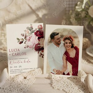 K&ouml;nnte beinhalten: Hochzeitseinladung mit Foto eines Paares und floralen Elementen. Die Einladung enth&auml;lt die Namen "Lucia + Carlos" und das Datum "24-04-2X". Das Design integriert bordeauxrote und rosa Blumen.