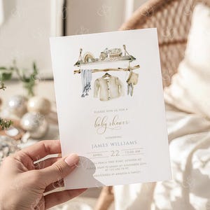 May include: Baby shower invitation with a watercolor illustration of baby clothes and accessories on a rack. The invitation includes the text "Please join us for a baby shower" and details for James Williams' baby shower on April 22nd.