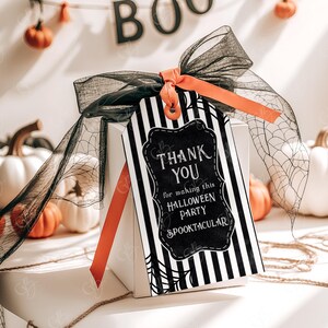 May include: Black and white striped gift tag with a black chalkboard style thank you message that says "Thank You for making this Halloween Party Spooktacular". The tag is tied with a black and orange ribbon and a black mesh bow.