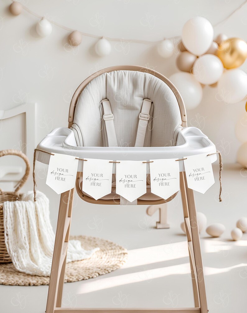 May include: A wooden high chair with a white fabric seat and a banner that says "YOUR design HERE" hanging from it. The banner is made of white cardstock with a brown twine string. The chair is decorated with a white and brown blanket and a wicker basket.