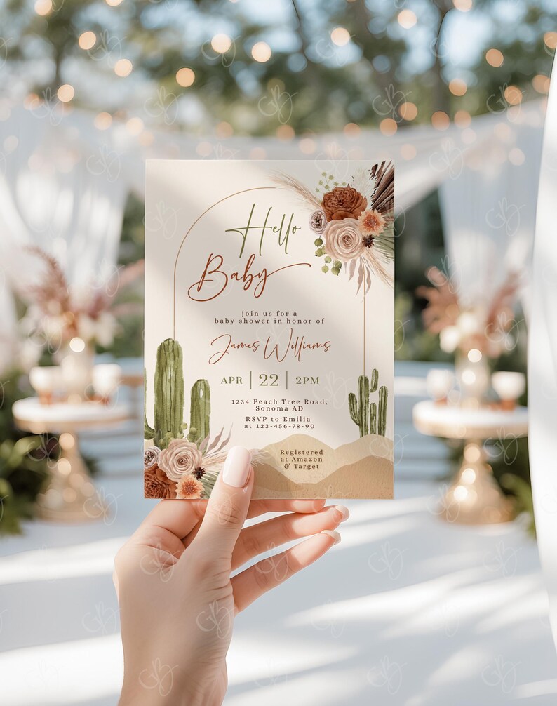 May include: A baby shower invitation with a desert theme. The invitation features a cactus, a floral arrangement, and the text "Hello Baby" in a handwritten font. The invitation also includes the date, time, and location of the shower, as well as the name of the guest of honor, James Williams. The invitation is registered at Amazon and Target.