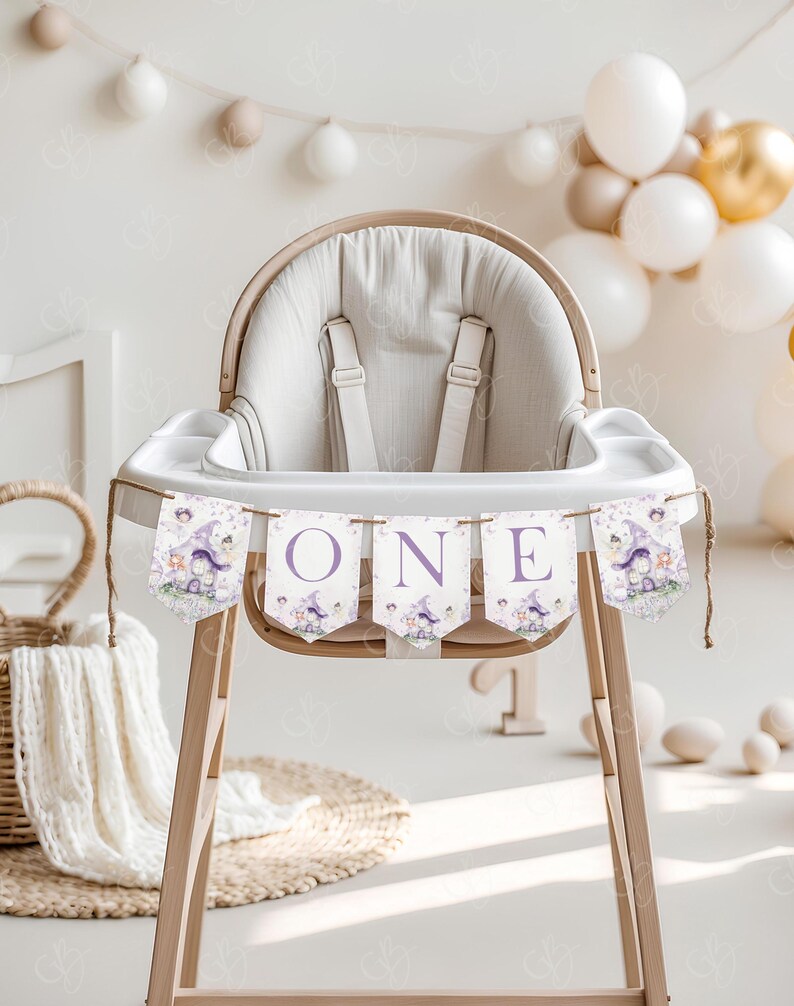 May include: A white high chair with a purple and white banner that says "ONE" with a fairy theme. The banner has images of fairies, mushrooms, and flowers.