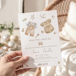 May include: A gender reveal invitation with the text "He or She" and "What will baby be?". The invitation features watercolor illustrations of baby clothes and accessories. The event is for James and Emilia on April 22nd.
