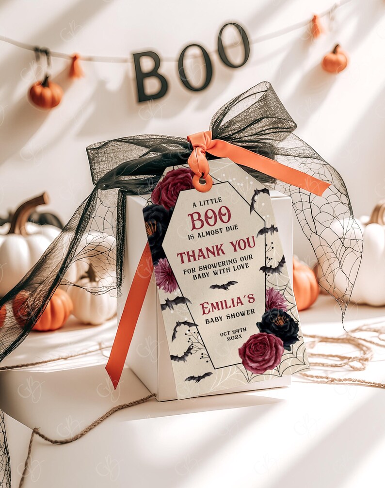 May include: A white gift box with a black and red Halloween themed gift tag. The tag says "A little Boo is almost due. Thank you for showering our baby with love. Emilia's Baby Shower Oct 24th 202X".