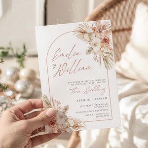 May include: Wedding invitation with floral and botanical design. The invitation features the names "Emilia & William" in a delicate script, along with event details. The design includes a floral arrangement with soft, neutral tones and the text "Their Wedding".