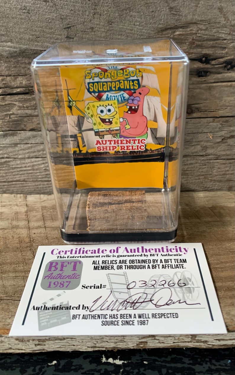 May include: A certificate of authenticity for a SpongeBob Squarepants movie ship relic. The certificate is white with black text and a black border. It has a serial number 032266 and is authenticated by "William Don". The text on the certificate reads "This Entertainment relic is guaranteed by BFT Authentic. ALL RELICS ARE OBTAINED BY A BFT TEAM MEMBER, OR THROUGH A BFT AFFILIATE. BFT Authentic 1987 Serial# 032266 Authenticated by BFT AUTHENTIC HAS BEEN A WELL RESPECTED SOURCE SINCE 1987."