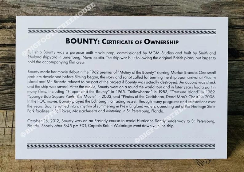 May include: A white certificate of ownership for the ship Bounty, a movie prop. The certificate details the ship's history, including its use in films like "Mutiny of the Bounty" and "Pirates of the Caribbean".