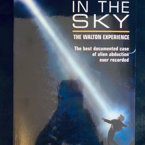 Puede incluir: Portada del libro "Fire in the Sky" de Travis Walton. La portada presenta un haz de luz que brilla sobre una persona con los brazos extendidos. El texto incluye "The Walton Experience" y "The best documented case of alien abduction ever recorded."