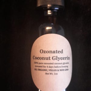 May include: A brown glass bottle with a dropper top and a white label that reads "Ozonated Coconut Glycerin 100% pure ozonated coconut glycerin ozonated for 4 days before freezing ALL ORGANIC, VEGAN & NON-GMO Net Wt. 1oz"