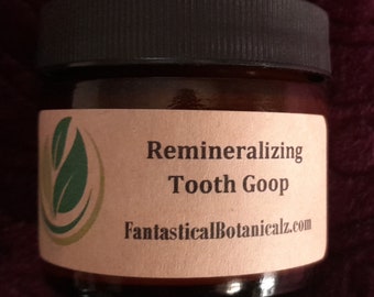 May include: A small brown glass jar with a black lid and a label that reads "Remineralizing Tooth Goop" and "FantasticalBotanicalz.com".