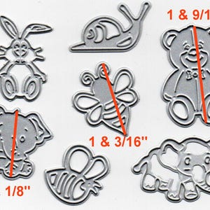 May include: A collection of silver-colored metal die cuts in various animal shapes, including a rabbit, snail, bear, bee, and two elephants. The bear measures 1 & 9/16 inches tall, and the elephant is 1 & 1/8 inches tall. These are ideal for crafting projects.
