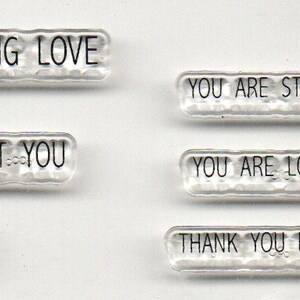 May include: Clear stamps with various positive messages, including "Stay Strong", "Be You", "Sending Love", "I Care About You", "Blessed to Know You", "You Are Stronger Than You Think", "You Are Lovely Inside and Out", and "Thank You For Being My Friend".