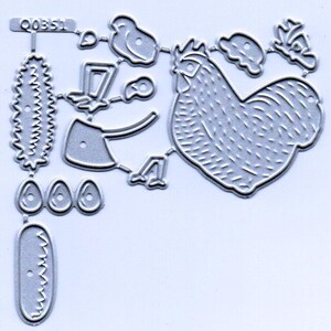 May include: A die-cut metal sheet featuring various farm-themed shapes. The design includes a rooster, eggs, a bird, an axe, and other decorative elements. The shapes are in a silver color.