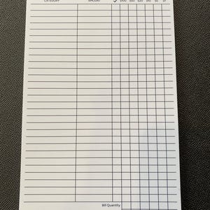 May include: A white cash planning sheet with columns for category, amount, and denominations from $100 to $1. The sheet includes spaces for bill quantity and total amount. The bottom of the sheet reads "Planners & Palm Trees".