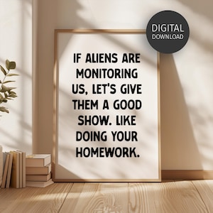 May include: A framed print with the text "IF ALIENS ARE MONITORING US, LET'S GIVE THEM A GOOD SHOW. LIKE DOING YOUR HOMEWORK." A digital download label is in the upper right corner. The frame is light brown.