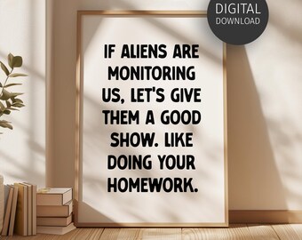 May include: A framed print with the text "IF ALIENS ARE MONITORING US, LET'S GIVE THEM A GOOD SHOW. LIKE DOING YOUR HOMEWORK." A digital download label is in the upper right corner. The frame is light brown.