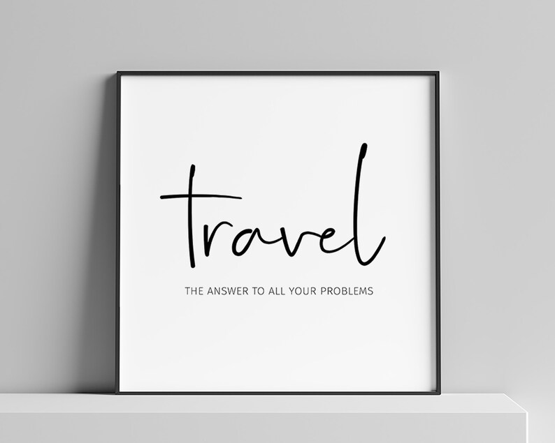 May include: A framed print with the word "travel" in a handwritten font. Below, the text reads "THE ANSWER TO ALL YOUR PROBLEMS". The print is in a black frame, set against a white background.