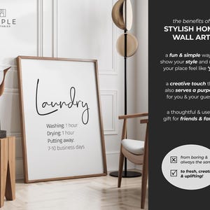 May include: A framed white print with the word "Laundry" in a stylish script. Below, it lists washing and drying times, and the time to put away. The print is in a room with a wooden side table, a decorative bird sculpture, and a modern floor lamp.