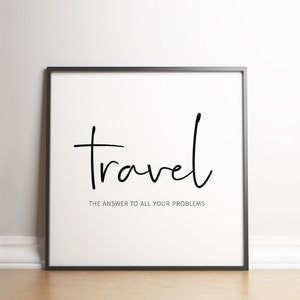 May include: A framed print with the word "travel" in a handwritten style, with the phrase "THE ANSWER TO ALL YOUR PROBLEMS" below it. The text is black on a white background, framed in a black frame.