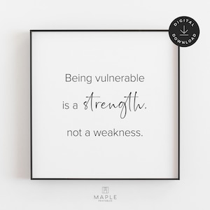 May include: A framed print with the text "Being vulnerable is a strength, not a weakness." The print is in black and white, with a black frame. A digital download icon is in the upper right corner.