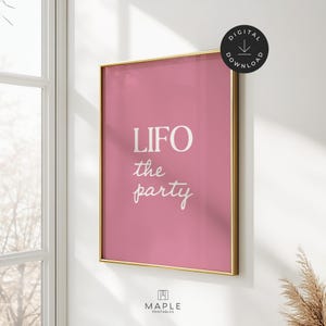 以下が含まれることがあります： 「LIFO the party」の白いスクリプトで書かれた、額入りのピンクのアートプリント。プリントは金色のフレームで、右上隅にデジタルダウンロードアイコンが付いています。Maple Printablesのロゴが下部にあります。
