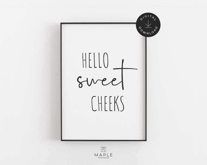 This image shows a framed vertical poster with the words “HELLO sweet CHEEKS” in a combination of uppercase and handwritten fonts. The funny bathroom print features black text on a white background and is displayed in a black frame. A small circle in the corner says “Digital Download.”