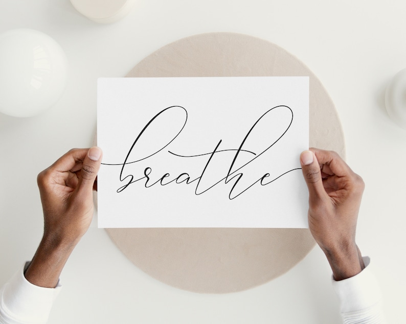 May include: A white card with the word "breathe" written in black cursive script.