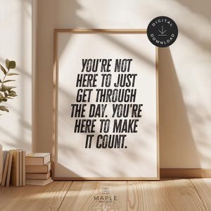 May include: A framed print with the text "YOU'RE NOT HERE TO JUST GET THROUGH THE DAY. YOU'RE HERE TO MAKE IT COUNT." in black letters. The print is in a light wood frame and is a digital download.