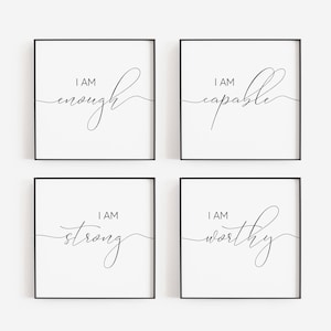 Puede incluir: Cuatro impresiones enmarcadas con marcos negros y fondos blancos. Cada impresión presenta las palabras "I AM" sobre una sola palabra en escritura elegante: "enough", "capable", "strong" y "worthy".
