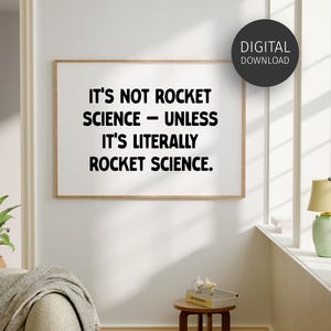 May include: A framed print with the text "IT'S NOT ROCKET SCIENCE - UNLESS IT'S LITERALLY ROCKET SCIENCE." The print is in a room with a sofa, a small table, and a lamp. A digital download sticker is in the upper right corner.