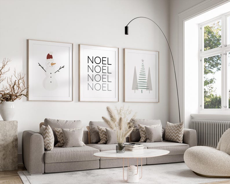 Pu&ograve; includere: Tre stampe incorniciate con un tema invernale. La prima stampa presenta un pupazzo di neve con un cappello rosso. La seconda stampa ha la parola "NOEL" ripetuta quattro volte. La terza stampa mostra un albero di Natale stilizzato.