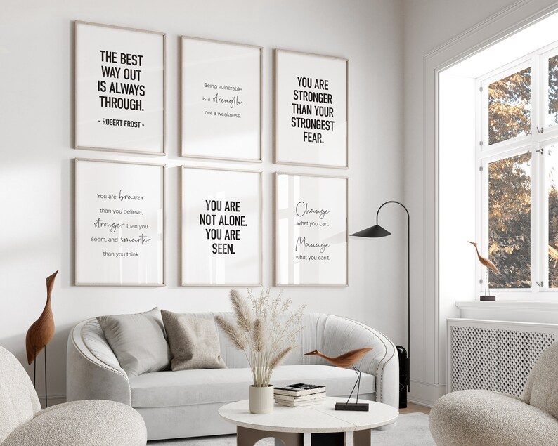 K&ouml;nnte beinhalten: F&uuml;nf Motivationszitate, die auf wei&szlig;em Papier mit schwarzem Text in Rahmen an einer wei&szlig;en Wand gedruckt sind. Die Zitate lauten: "Der beste Weg nach drau&szlig;en ist immer durch. -Robert Frost-", "Verletzlich zu sein ist eine St&auml;rke, keine Schw&auml;che", "Du bist st&auml;rker als deine gr&ouml;&szlig;te Angst", "Du bist mutiger, als du glaubst, st&auml;rker, als du scheinst, und kl&uuml;ger, als du denkst", "Du bist nicht allein. Du wirst gesehen."