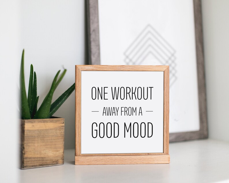 May include: A wooden framed sign with white background and black text that reads "ONE WORKOUT - AWAY FROM A - GOOD MOOD".